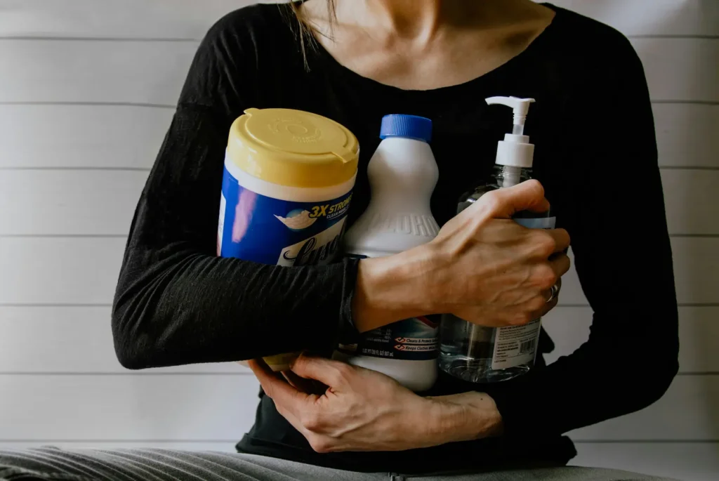 Woman holding conventional cleaning products