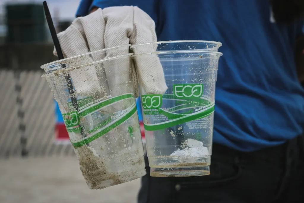 A person picking up plastic cups labeled as Eco