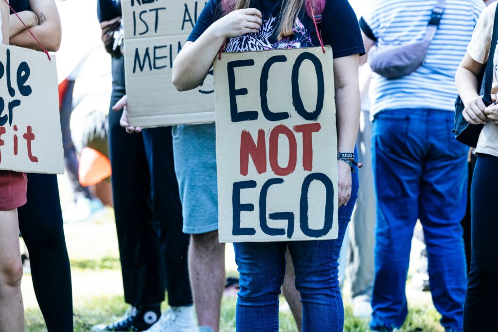 A protester holding a sign that reads "Eco not Ego"